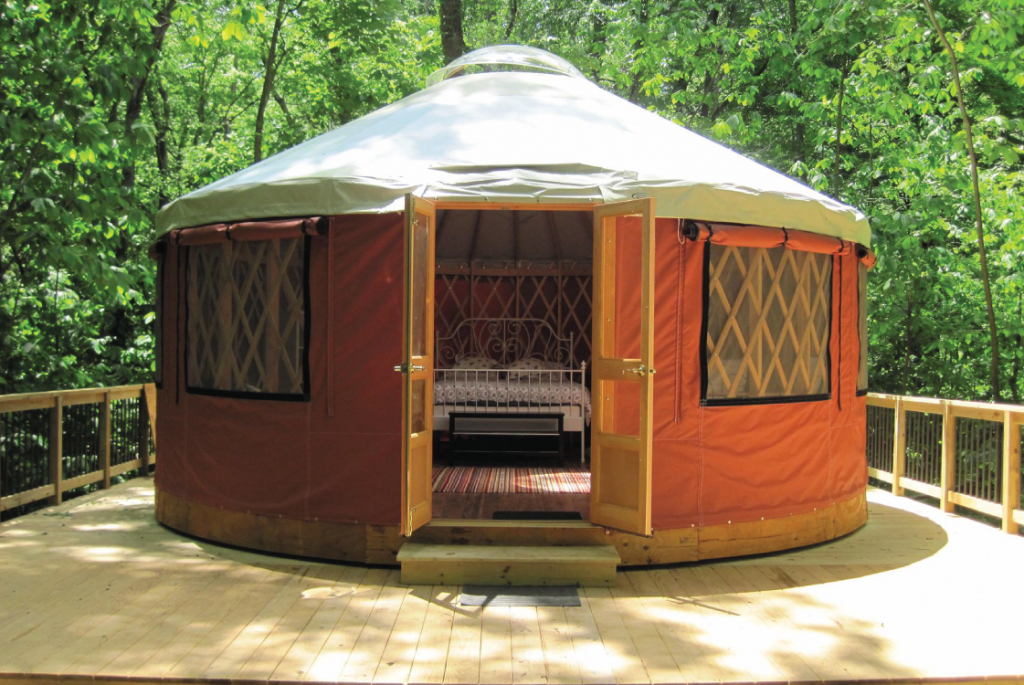 Yurt with open door leading to outside.